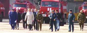 Sergei Shoigu and his special-purpose group on the way to the crash site. A Spetsnaz Colonel (wearing a suit) is talking on a mobile phone. The Army General, Rashid Nurgaliyev (wearing a "kepi" cap), buttons his jacket.
